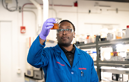 Scientist in a lab looking at flask